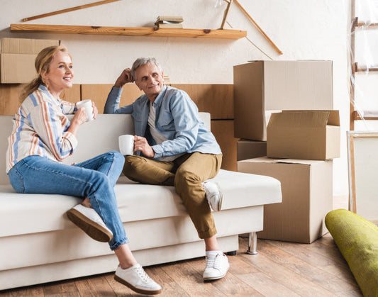 couple sitting on couch with moving boxes