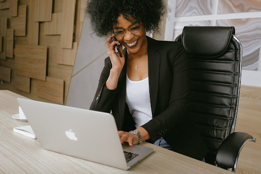 Woman talking on phone in an office sitting on leather office chair