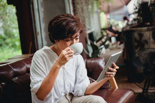 woman drinking coffee sitting on couch